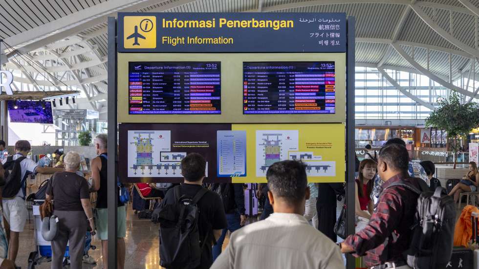 epa12182596 People view flight information at Ngurah Rai International Airport in Bali, Indonesia, 18 June 2025. Numerous flights to and from Bali were canceled following the eruption of Mount Lewotobi Laki-Laki in East Nusa Tenggara on 17 June 2025. The volcano sent a massive ash plume soaring 10 km high.  EPA/MADE NAGI