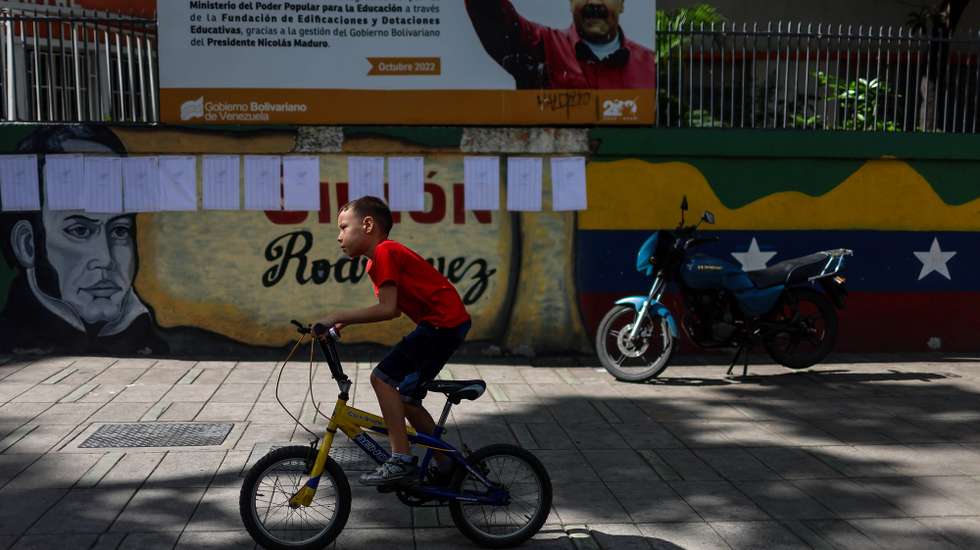 epa12135890 A boy on a bicycle rides past a polling station in Carcas, Venezuela, 25 May 2025. The regional and legislative elections in Venezuela, where governors, national deputies, and state legislators are being elected, were marked by the absence of long lines seen in previous years and the use of automated voting, which both Chavistas and opposition groups described as 'fast.'  EPA/MIGUEL GUTIERREZ
