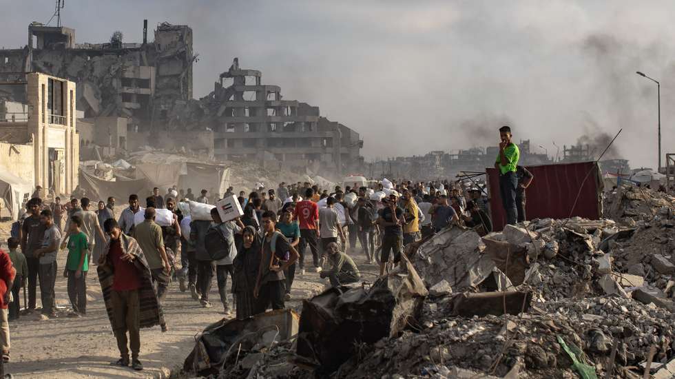 epa12191498 Displaced Palestinians carry relief packages along Rashid Street, west of Jabalia, 22 June 2025, after humanitarian aid trucks entered the northern Gaza Strip through the Israeli-controlled Zikim crossing, northwest of Gaza City. More than 55,700 Palestinians have been killed in the Gaza Strip, according to the Palestinian Ministry of Health, since Israel launched a military campaign in the strip in response to a cross-border attack led by the Palestinian militant group Hamas on 07 October 2023.  EPA/HAITHAM IMAD