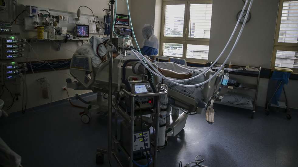 Uma enfermeira cuida de um paciente hospitalizado na Unidade de Cuidados Intensivos Covid 19 do Hospital Santa Maria em Lisboa, 27 de outubro de 2020. A urgência dedicada aos casos suspeitos de covid-19 do Hospital Santa Maria, em Lisboa, reflete a evolução da pandemia em Portugal com doentes a avolumarem-se à porta para realizar o teste e no interior a capacidade quase esgotada. O medo de perder o emprego leva muitos doentes com covid-19 a esconderem que estão infetados e a continuar a trabalhar, disseminando a doença que, nesta fase, começa a ser um caso também social e que leva a muitos internamentos no Santa Maria. (ACOMPANHA TEXTO DA LUSA DE 30 DE OUTUBRO DE 2020) TIAGO PETINGA/LUSA