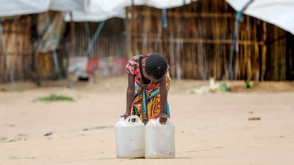 epa09127275 A young displaced girl carries water bidons in 25 June Camp for Internally Displaced People (IDP) in Belibize, near Metuge, northern Mozambique, 10 April 2021. The violence unleashed more than three years ago in Cabo Delgado province escalated again about two weeks ago, when armed groups first attacked the town of Palma, forcing people to flee from a conflict zone.  EPA/JOAO RELVAS