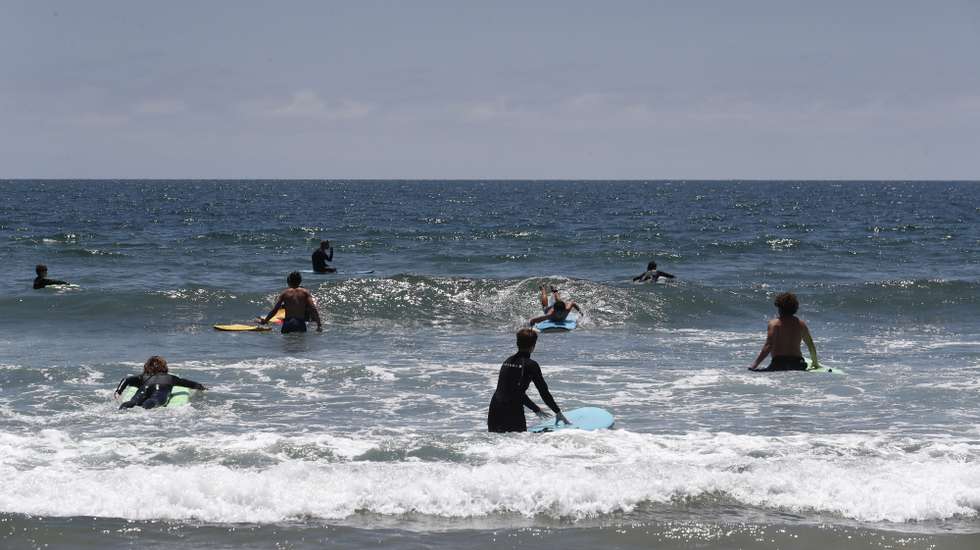 epa10054138 People surf at Venice Beach in Los Angeles, California, USA, 05 July 2022.  EPA/CAROLINE BREHMAN