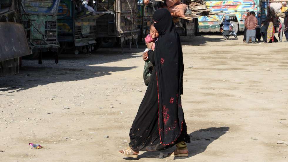 epa11001380 An Afghan refugee woman holds a baby as she walks at a registration center, after arriving from Pakistan, near the Afghanistan-Pakistan border in Spin Boldak district of Kandahar province, Afghanistan, 28 November 2023 (issued on 29 November 2023). About 1,7 million undocumented Afghans migrants who were in Pakistan have been affected by the 01 November deadline to leave the country, given to them by the Pakistani government, and as a result thousands of Afghans having to leave the country in a hurry. Pakistan's caretaker Prime Minister Anwaar-ul-Haq Kakar said his government's decision was in response to the Afghan administration's unwillingness to take action against the main Taliban group in the Asian country, the Tehreek-e-Taliban Pakistan (TTP).  EPA/STRINGER