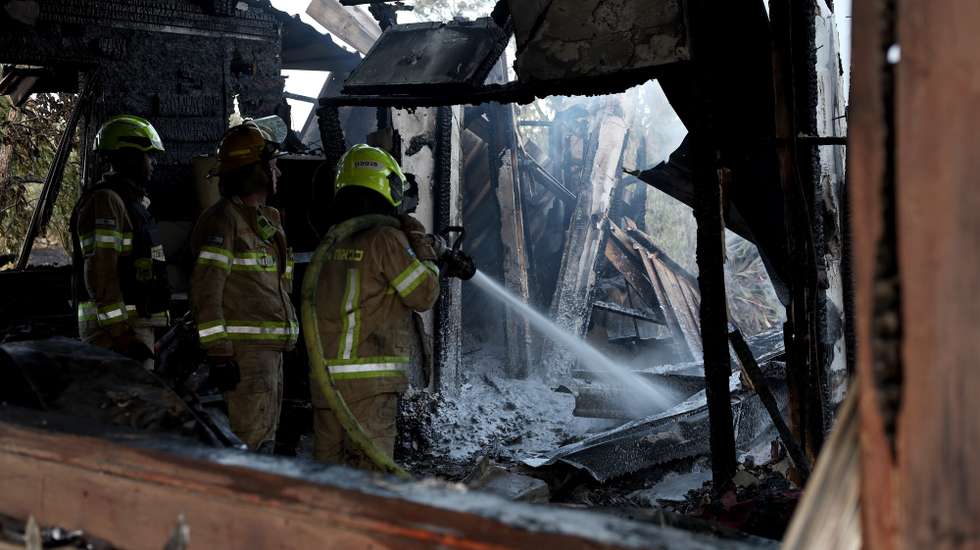 epa11617813 A firefighter douses a fire coming from projectiles fired from south Lebanon near Safed, northern Israel, 21 September 2024. The Israeli Defense Forces (IDF) said that "approximately 90 projectile launches were identified crossing from Lebanon into Israeli territory." Furthermore, the Air Force "struck thousands of launcher barrels that were ready for immediate use to fire toward Israeli territory."  EPA/ATEF SAFADI