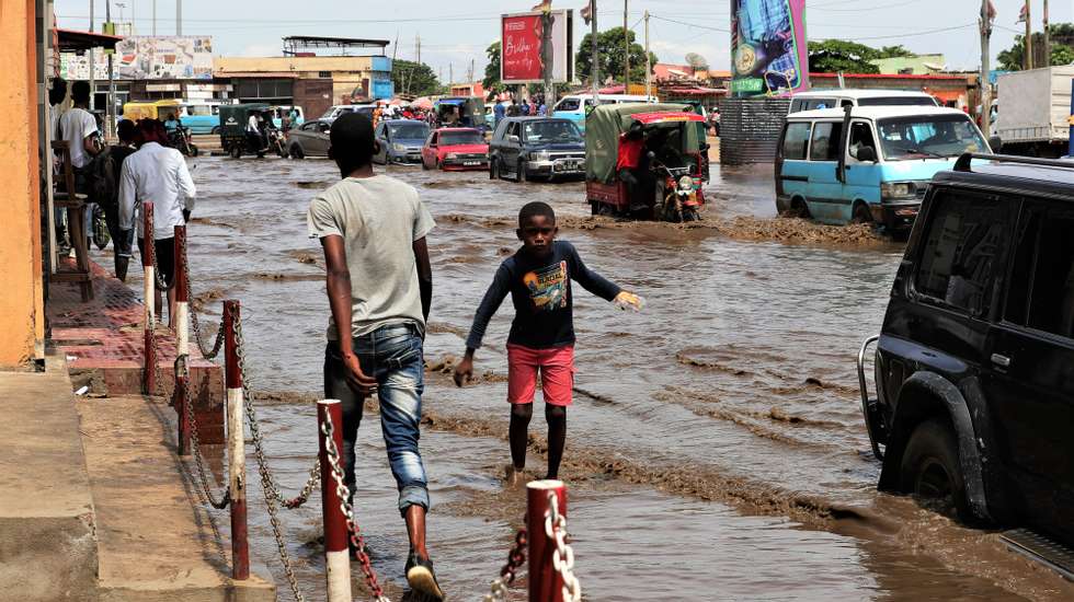 epa10579121 Locals walk next to flood waters caused by rainfall in Luanda, Angola, 18 April 2023. Since last week the rains that fell in Luanda area have caused the death of at least seven people, including three children in the early hours of 18 April, in addition to falling trees, thousands of flooded homes and collapsed electricity pylons.  EPA/AMPE ROGERIO