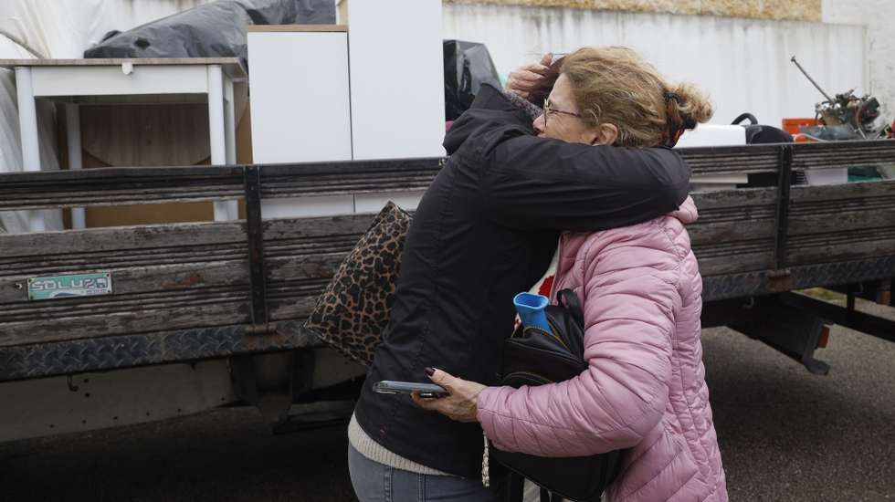Duas mulheres reagem após terem sido forçadas a retirar os bens das suas casas na Azinhaga do Formozinho, Porto Brandão, em Almada, 13 de fevereiro de 2026. Dezasseis pessoas morreram em Portugal na sequência da passagem das depressões Kristin, Leonardo e Marta, que provocaram também muitas centenas de feridos e desalojados. ANTÓNIO PEDRO SANTOS/LUSA