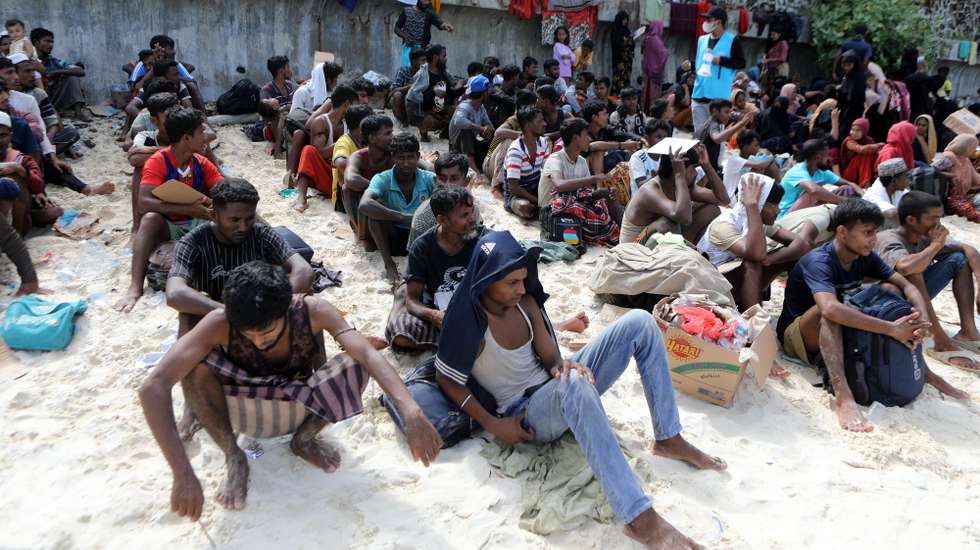 epa10989311 Rohingya refugees wait at an open area after arriving on a beach at Ujong Kareung, Weh Island, Sabang, Indonesia, 22 November 2023. According to the UNHCR, around 200 Rohingya refugees landed in Sabang, Weh Island, after sailing across the Indian Ocean. UNHCR data states that almost 1,000 more Rohingya refugees have arrived in Aceh since the beginning of November 2023 in several waves of voyages headed to Indonesia and Malaysia.  EPA/HOTLI SIMANJUNTAK