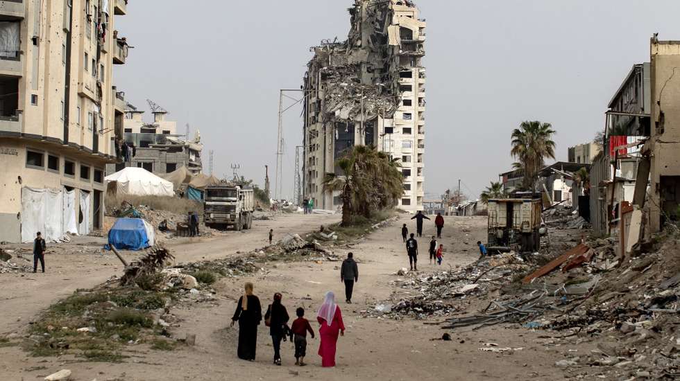epa12014210 Internally displaced Palestinians walk past destroyed buildings in the west of Gaza City, the Gaza Strip, 06 April 2025, after the Israeli army issued evacuation orders for areas in the northern and eastern Gaza Strip. Israeli forces resumed airstrikes on Gaza on 18 March, ending a ceasefire that had been in place since 19 January.  EPA/HAITHAM IMAD