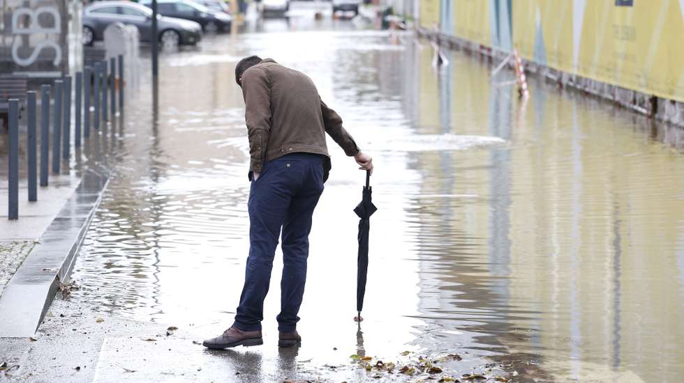 Um popular observa uma rua inundada após fortes chuvas e o mau tempo sentido esta manhã no distrito de Lisboa causou inundações e afetou o tráfego rodoviário, em Alcântara, Portugal, 13 de dezembro de 2022. A proteção civil nacional apelou hoje aos cidadãos para restringirem ao máximo as deslocações por causa do mau tempo, que provocou na noite de hoje 275 ocorrências nos distritos de Lisboa e Setúbal e deverá manter-se até quarta-feira. ANTÓNIO PEDRO SANTOS/LUSA
