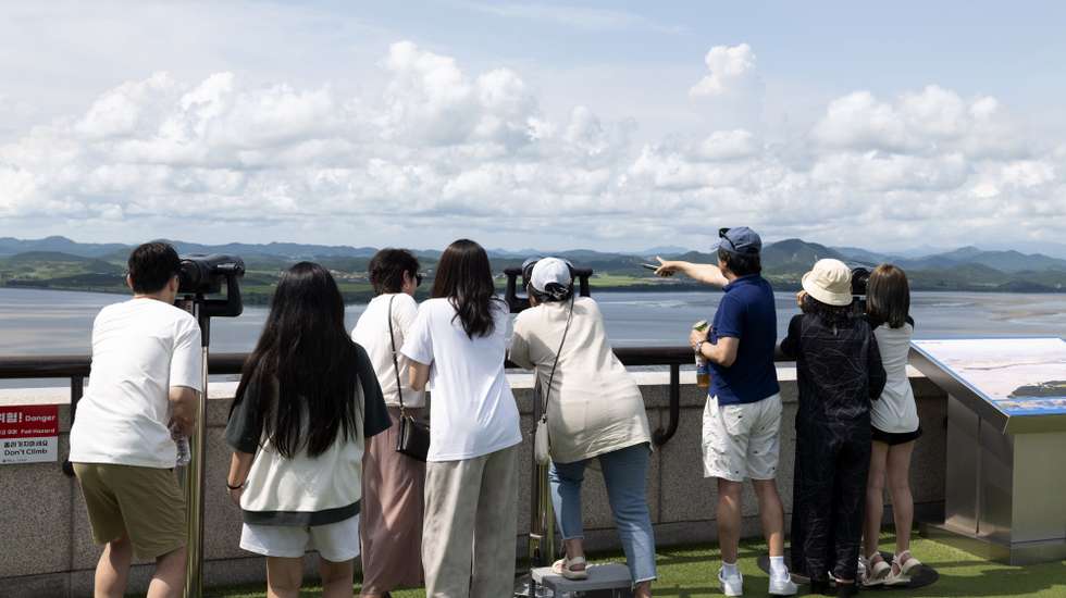 epa12335578 People look through binoculars toward the North Korean side of the border from the Odusan observatory, near the Demilitarized Zone (DMZ), in Paju, Gyeonggi Province, South Korea, 30 August 2025. In a rare overseas trip with other world leaders, including Russian President Vladimir Putin, North Korean leader Kim Jong-un will visit Beijing to attend China's military parade marking the 80th anniversary of Japan's defeat in World War II, according to North's Korean Central News Agency (KCNA).  EPA/JEON HEON-KYUN