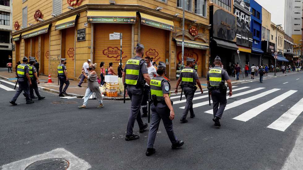 epa08904934 Members of Brazilian police patrol in front of closed stores due to the coronavirus pandemic at 25 de Marzo street, the major commerce centre in Sao Paulo, Brazil, 26 December 2020.  EPA/Sebastiao Moreira