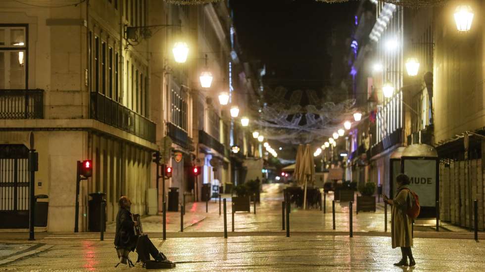 Um acordeonista toca para uma transeunte na Rua Augusta no recolher obrigatório do estado de emergência no âmbito das medidas de contenção da covid-19, Lisboa, 9 de novembro de 2020. O Presidente da República, Marcelo Rebelo de Sousa, decretou o estado de emergência em Portugal, por 15 dias, a partir de hoje para permitir medidas de contenção da covid-19. TIAGO PETINGA/LUSA