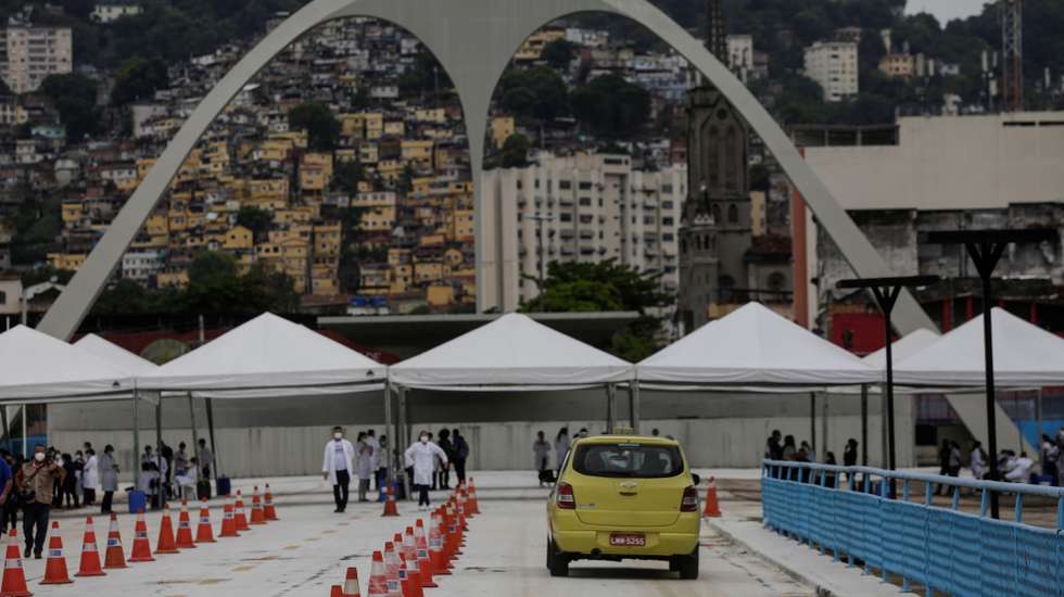 epa08991985 Vehicles are driven through the 'Samba's Passarela' to reach a vaccination center, in Rio de Janeiro, Brazil, 06 February 2021. The sambadrome has been turned into a covid-19 vaccination place for older adults.  EPA/ANTONIO LACERDA