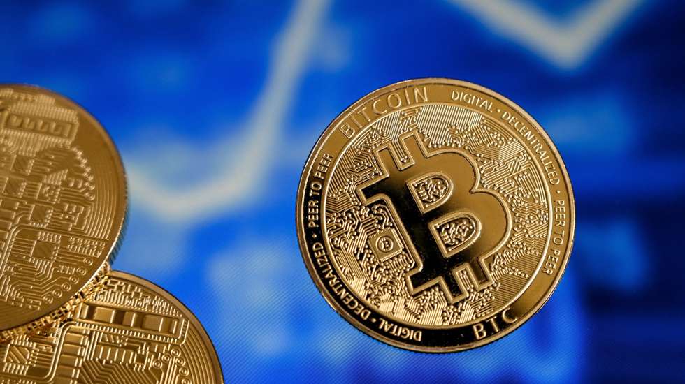 epa09018336 A bitcoin reflects in front of a monitor showing a stock barometer in Duesseldorf, Germany, 17 February 2021. For the first time, the cryptocurrency Bitcoin has exceeded the mark of 50,000 dollars. Most recently, it became known that Elon Musk, CEO of the US electric car manufacturer Tesla, is said to have invested 1.5 billion dollars in Bitcoin. In recent weeks, he had boosted Bitcoin as well as other Internet currencies with positive news via the short message service Twitter. Credit card provider MasterCard also announced that it would open its payment network to cryptocurrencies. Visa plans to help banks introduce trading with Bitcoin and other cryptocurrencies by launching software with API access.  EPA/SASCHA STEINBACH