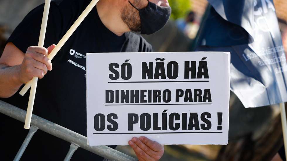 Um participante exibe um cartaz onde se lê "Só Não Há Dinheiro Para Os Polícias!" durante a jornada de protesto dos elementos da PSP e da GNR com o objetivo de "sensibilizar todos os cidadãos para a problemática da não atribuição do suplemento de risco aos polícias da PSP e militares da GNR", junto ao Palácio da Ajuda, local onde decorre a reunião do Conselho de Ministros, em Lisboa, 15 de julho de 2021. Convocado pelos sindicatos da Polícia de Segurança Pública (PSP) e associações da Guarda Nacional Republicana (GNR) - Associação Nacional de Guardas; Associação Nacional de Sargentos da Guarda Associação Sócio Profissional Independente dos Profissionais da GNR; Associação Sindical Autónoma de Polícias; Organização Sindical dos Polícias; Sindicato Independente de Agentes de Polícia; Sindicato Independente Livre Polícia; Sindicato Nacional da Polícia; Sindicato Nacional Carreira de Chefes PSP; Sindicato Nacional Oficiais de Polícia; Sindicato Profissionais de Polícia; Sindicato de Polícia pela Ordem e Liberdade; Sindicato Vertical da Carreira de Polícia. ANTÓNIO COTRIM/LUSA