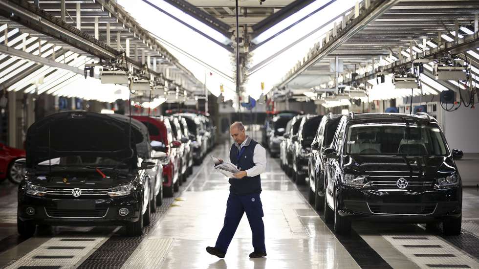 Um trabalhador da fábrica Autoeuropa do grupo alemão Volkswagen passa pela linha de sáida de veículos produzidos numa altura em que se celebram os 20 anos do início da produção da Autoeuropa em Portugal, em Palmela, concelho de Setúbal, 26 de abril de 2015. (ACOMPANHA TEXTO) MÁRIO CRUZ/LUSA