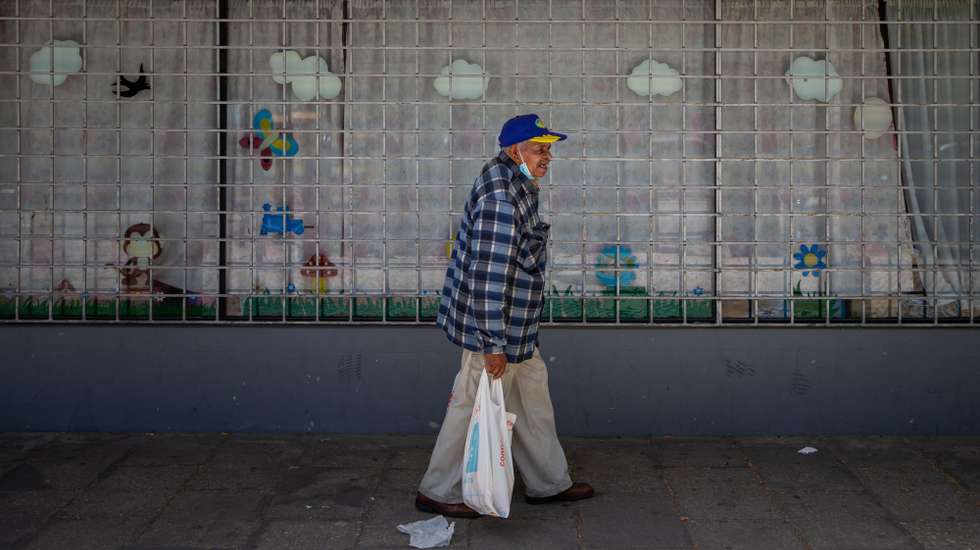 Um morador do Bairro Branco, carrega sacos de alimentos provenientes do Banco Alimentar contra a Fome, na Associação Padre Amadeu Pinto, que funciona desde 2007 e atua na prevenção contra o crime, apoio a crianças em contexto de pobreza e distribuição de alimentos, no Bairro Branco, Pragal, Almada, 22 de abril de 2021. (ACOMPANHA TEXTO DE 03 DE MAIO DE 2021). JOSÉ SENA GOULÃO/LUSA