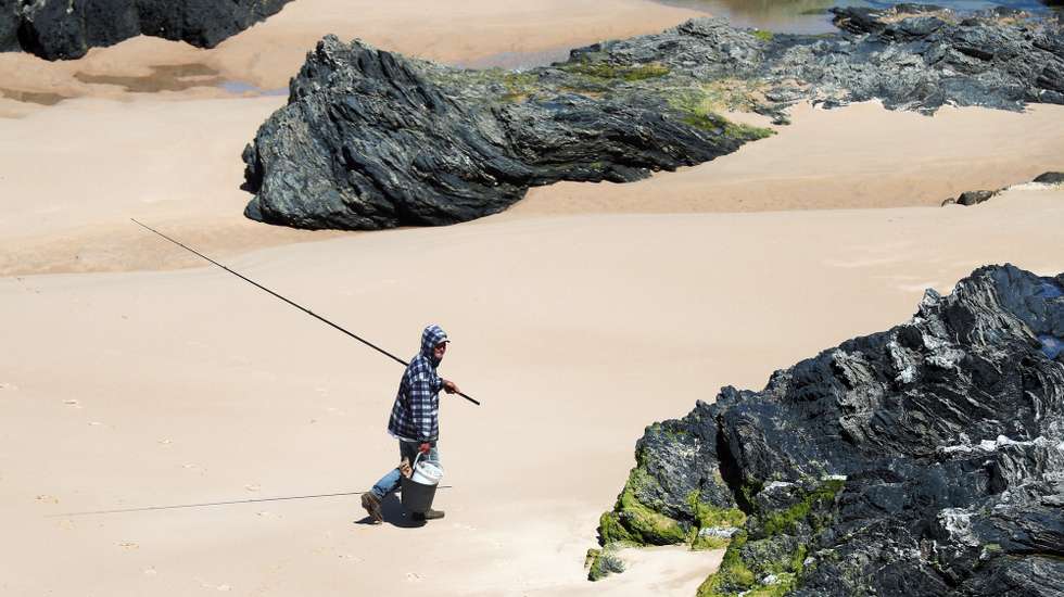 Um pescador numa praia do sudoeste alentejano, na região do Parque Natural do Sudoeste Alentejano e Costa Vicentina, onde há quem defenda que pode faltar a água em poucos anos, em Odemira, 10 de maio de 2021. Com o aumento das estufas e demais produções de agricultura intensiva a falta de água na barragem de Santa Clara é insistentemente referida nas mais diferentes conversas com os mais diferentes protagonistas na região do sudoeste alentejano. (ACOMPANHA TEXTO DA LUSA DE 21 DE MAIO DE 2021). NUNO VEIGA/LUSA