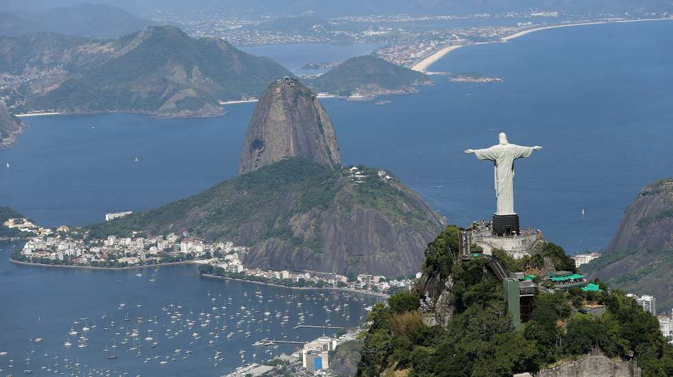 epa09520096 (FILE) - An aerial view of the Christ the Redeemer (Cristo Redentor) statue atop Corcovado Mountain overlooking the city towarss Sugarloaf Mountain (Pao de Acucar hill, C) in Rio de Janeiro, Brazil, 07 February 2014 (reissued 12 October 2021). The 'Marvellous City' is celebrating the 90th anniversary of Rio's Christ the Redeemer statue's unveilling of 12 October 1931.  EPA/MARCELO SAYAO *** Local Caption *** 51299671