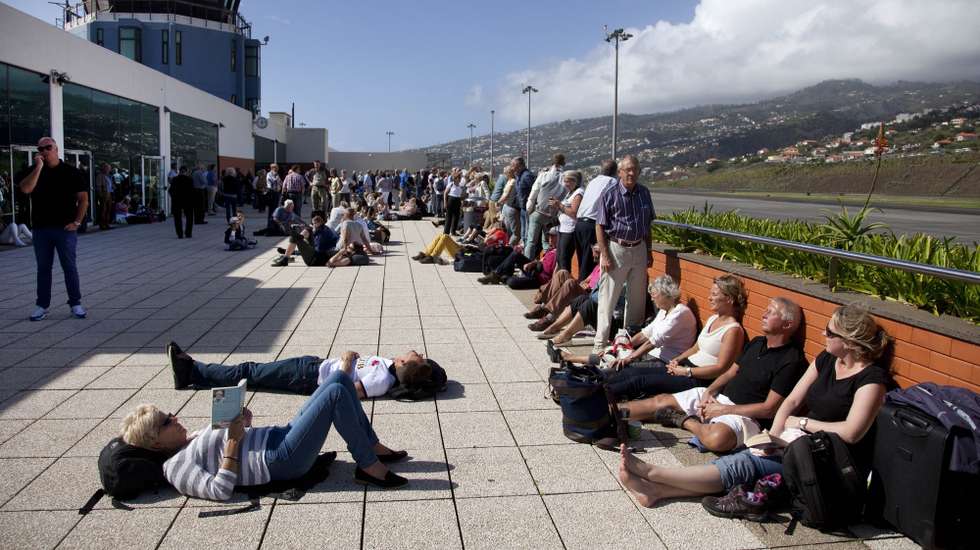 Passageiros aguardam por avião no exterior do aeroporto da Madeira, no Funchal, 20 de outubro de 2014. Os voos têm sido cancelados devido ao vento forte que se faz sentir na Ilha da Madeira deixando centenas de passageiros no aeroporto da Madeira. PAULO CUNHA/LUSA