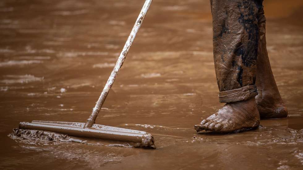 epa09679436 A man cleans mud from the floods caused by heavy rains in Sabara, Minas Gerais state, Brazil, 11 January 2022. At least 10 people died and a hundred more had to leave their homes in the last 24 hours, due to the heavy rains that hit the Minas Gerais region, the second state most affected by downpours in Brazil in recent weeks, reported the Civil Defense.  EPA/Thomas Santos