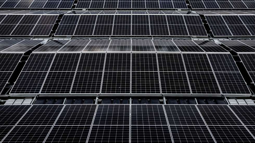 epa10094440 An aerial photo taken with a drone shows solar panels on Germany's biggest floating photovoltaic plant on lake Silbersee in Haltern, Germany, 27 July 2022. More than 5,000 photovoltaic modules produce around 3 million kilowatt hours of electricity per year, saving 1,100 tons of CO2 to fight climate change with renewable power instead of oil, gas and coal.  EPA/SASCHA STEINBACH