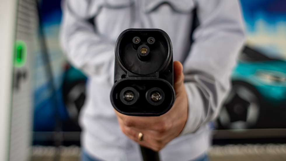 epa10650225 A Volkswagen employee poses with a charging plug at the Volkswagen (VW) vehicle factory in Zwickau, Germany, 24 May 2023. The plant in Zwickau, completely re-equipped for electric mobility for a total of 1.2 billion euros, produces exclusively all-electric vehicles and has become the largest and highest-performance electric car plant in Europe for the Volkswagen group.  EPA/MARTIN DIVISEK