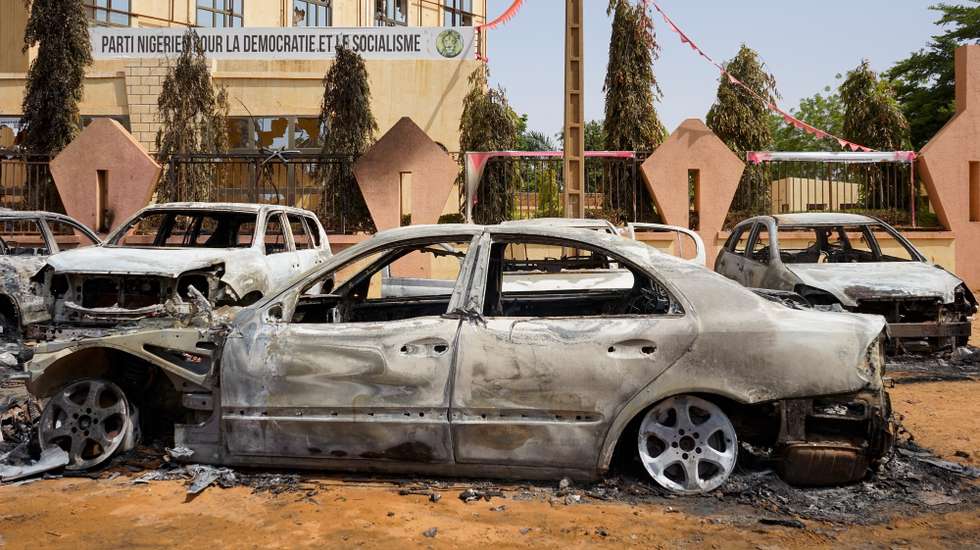 epa10773372 Torched cars sit in front of the headquarters of the Nigerien Party for Democracy and Socialism, which was damaged during anti-government protests in Niamey, Niger, 29 July 2023. Mutinous soldiers calling themselves the 'National Council for the Safeguarding of the Country' claimed to have overthrown President Mohamed Bazoum, Niger's democratically elected president, in a televised address on 26 July evening. Protesters went out on 27 July in the streets of Niamey to support mutinous soldiers and demand the end of foreign intervention in the country. They also set fire to the building housing the headquarters of the ousted president's party.  EPA/ISSIFOU DJIBO