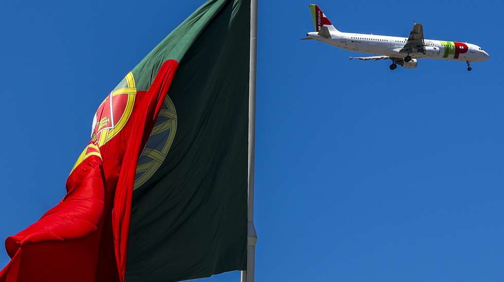 Um avião da TAP voa sobre uma bandeira de Portugal, no Parque Eduardo VII, em Lisboa, 10 de julho de 2023. JOSÉ SENA GOULÃO/LUSA