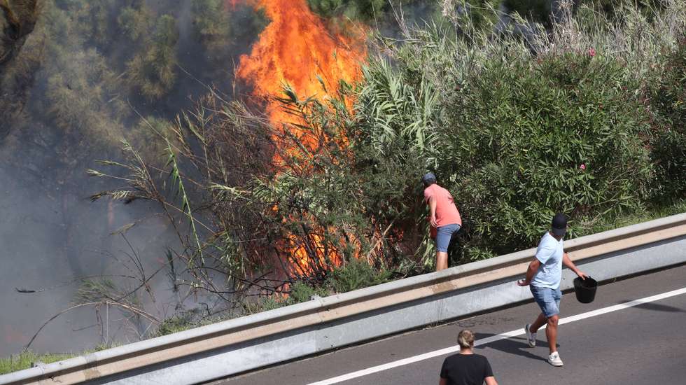 Populares tentam apagar o incêndio no concelho da Calheta, Madeira, 12 de outubro de 2023. O incêndio deflagrou cerca das 18:00 de quarta-feira na freguesia dos Prazeres, no município da Calheta, na zona oeste da Madeira, e motivou a retirada de 120 hóspedes do Hotel Jardim Atlântico”, cerca das 20:00, embora o fogo não tenha atingido a infraestrutura. HOMEM DE GOUVEIA/LUSA