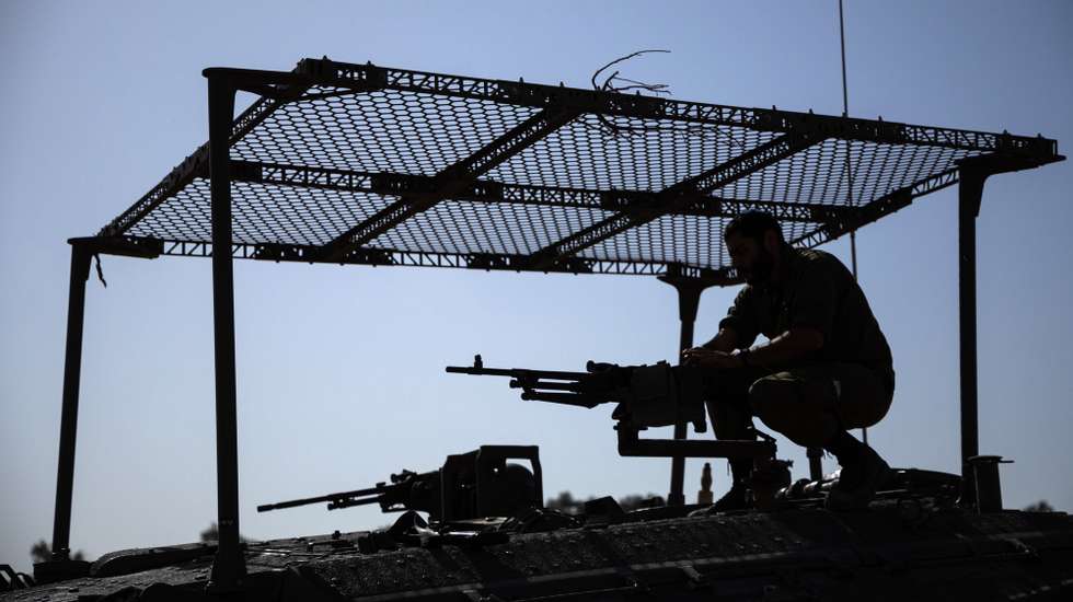 epaselect epa10990647 An Israeli soldier mans a machine gun on top of an armored vehicle at the border with the Gaza Strip, southern Israel, 23 November 2023. More than 12,700 Palestinians and at least 1,200 Israelis have been killed, according to the Israel Defense Forces (IDF) and the Palestinian health authority, since Hamas militants launched an attack against Israel from the Gaza Strip on 07 October, and the Israeli operations in Gaza and the West Bank which followed it. As part of Israel's 'ground operation' in the Gaza Strip, aerial strikes were carried out on over 300 Hamas targets over the last day, the IDF announced on 23 November.  EPA/CHRISTOPHE PETIT TESSON