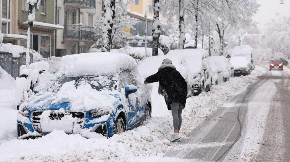 epa11006934 A woman cleans her snow-covered car in Munich, Germany, 02 December 2023. Due to heavy snowfall, flight operations at Munich Airport have been temporarily suspended until 03 December at 6 a.m., the airport announced. Several railway lines around Bavaria's state capital Munich had to be closed overnight, Deutsche Bahn (DB) said. Snowfall is expected to continue throughout the day in south and southeast Germany with as much as 20 to 40 cm of snow covering some areas of Bavaria, followed by frost and partly slippery conditions, the German Meteorological Service (DWD) warned.  EPA/ANNA SZILAGYI