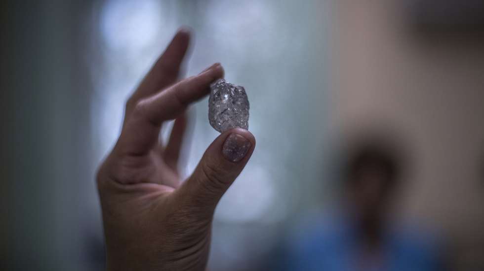 epa07691087 (29/40) A specialist shows a rough diamond at the ALROSA Diamond Sorting Center (DSC) in Mirny, Sakha (Yakutiya) Republic, Russia, 19 June 2019. The Russian diamond mining company ALROSA operates 12 kimberlite pipes and 16 alluvial deposits in the country's Republic of Sakha (Yakutia) and Arkhangelsk region and employs some 37,000 people at its facilities.  EPA/SERGEI ILNITSKY ATTENTION: For the full PHOTO ESSAY text please see Advisory Notices epa07691056 and epa07691057