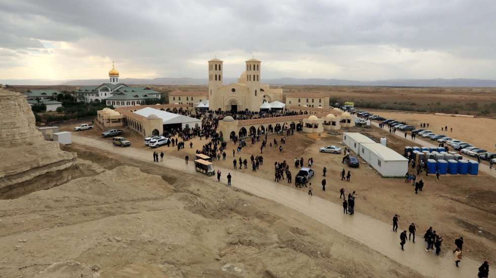 epa11071530 Members of the Catholic Church hold a Friday mass at the baptism site on the Jordanian side of the Jordan River during an annual pilgrimage to the site, in the Jordan Valley, Jordan, 12 January 2024. Christians believe that this site is where John the Baptist baptized Jesus Christ in the Jordan River.  EPA/MOHAMMAD ALI