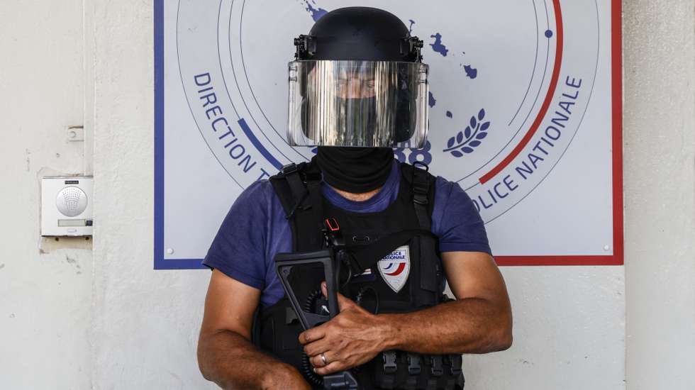 epa11362008 A member of police stands guard ahead of the arrival of French President Emmanuel Macron at the central police station in Noumea, France's Pacific territory of New Caledonia, 23 May 2024. Macron flew to France's Pacific territory of New Caledonia aiming to defuse a crisis after nine days of riots that have killed six people and injured hundreds.  EPA/LUDOVIC MARIN / POOL MAXPPP OUT