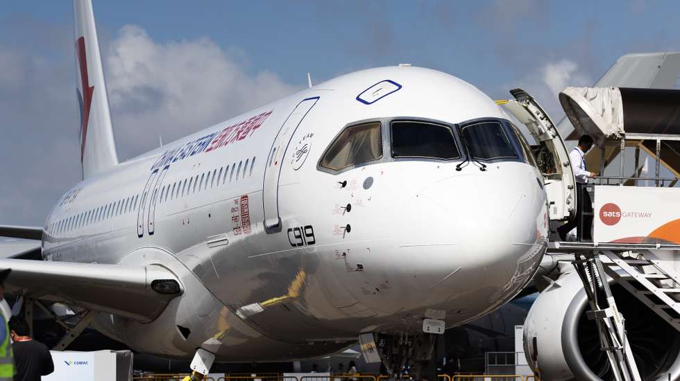 epa11167198 A staff personnel walks out of China's Comac C919 aircraft displayed during the first day of the Singapore Airshow at Changi Exhibition Centre in Singapore, 20 February 2024. The biennial Singapore Airshow runs from 20 to 25 February after a two-year hiatus due to the COVID-19 pandemic.  EPA/HOW HWEE YOUNG