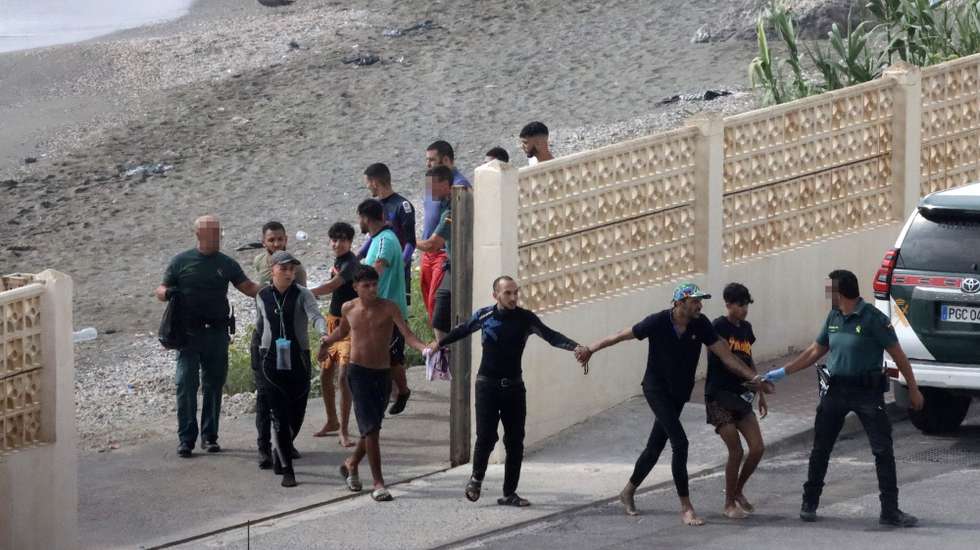 epa11565244 Members of the Spanish Guardia Civil (Civil Guard) detain migrats who have just entered Ceuta, Spanish enclave in the North of Africa, 26 August 2024. Since 25 August, migrants have been entering Spanish territory through Ceuta's beaches, taking advantage of thick fog in the area.  EPA/REDUAN ATTENTION EDITORS: IMAGE PIXELATED AT SOURCE TO COMPLY WITH SPANISH LAW