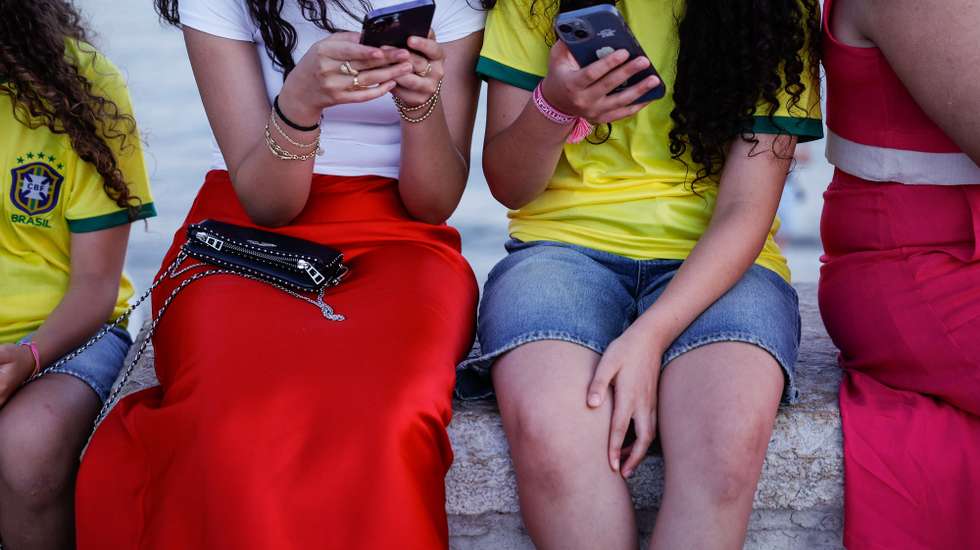 Duas jovens consultam o telemóvel, em Lisboa, 07 de agosto de 2024. Adolescência. Comunicações. Internet. ANTÓNIO PEDRO SANTOS/LUSA