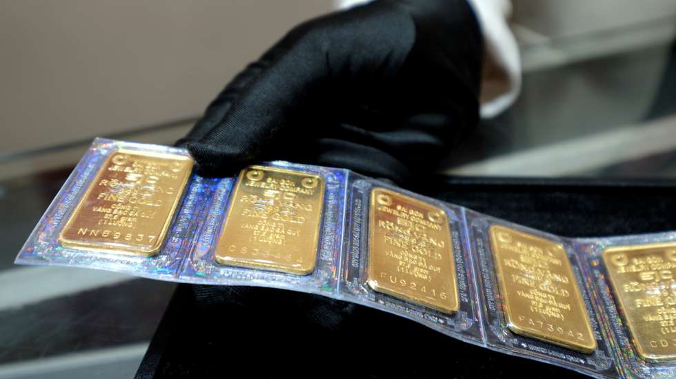 epa11269014 A saleswoman picks up gold bars at a jewelry shop in Hanoi, Vietnam, 10 April 2024. The price of gold in Vietnam has soared to record high price recently. Vietnamese Prime Minister Pham Minh Chinh ordered the central bank to take measures to stabilize the market and narrow the price gap between the international and domestic gold rate.  EPA/LUONG THAI LINH