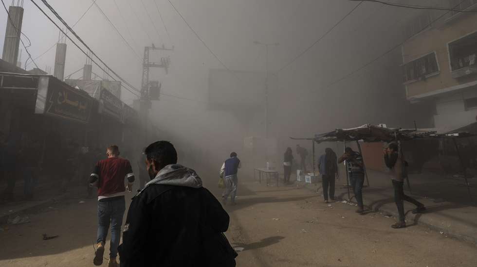 epa11736326 Palestinians take cover as smoke rises following an Israeli airstrike on the Al Farouq Mosque in the Al Nuseirat refugee camp, central Gaza Strip, 23 November 2024. More than 44,000 Palestinians, including over 13,000 children, have been killed according to the Palestinian Ministry of Health and over 1,400 Israelis have been killed according to the Israeli army, since Hamas militants launched an attack against Israel from the Gaza Strip on 07 October 2023, and the Israeli operations in Gaza and the West Bank which followed it.  EPA/MOHAMMED SABER