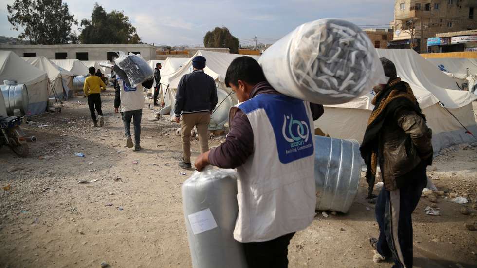 epa11757034 Dipslaced families collect aid provided by the United Nations (UN) during the visit of a UN delegation at a refugee camp, in the town of Al-Bardaqli, northern Syria, 04 December 2024. Tens of thousands of Syrians have been displaced in recent fighting between rebels and the government in northwest Syria, the UN said on 03 December. Syrian opposition forces, led by the Islamist militant group Hayat Tahrir al-Sham (HTS), launched an offensive on 27 November, taking large parts of Aleppo, Syria's second-largest city, triggering counterattacks by the Syrian regime forces as well as Russian and Syrian airstrikes on opposition-controlled areas.  EPA/BILAL AL HAMMOUD
