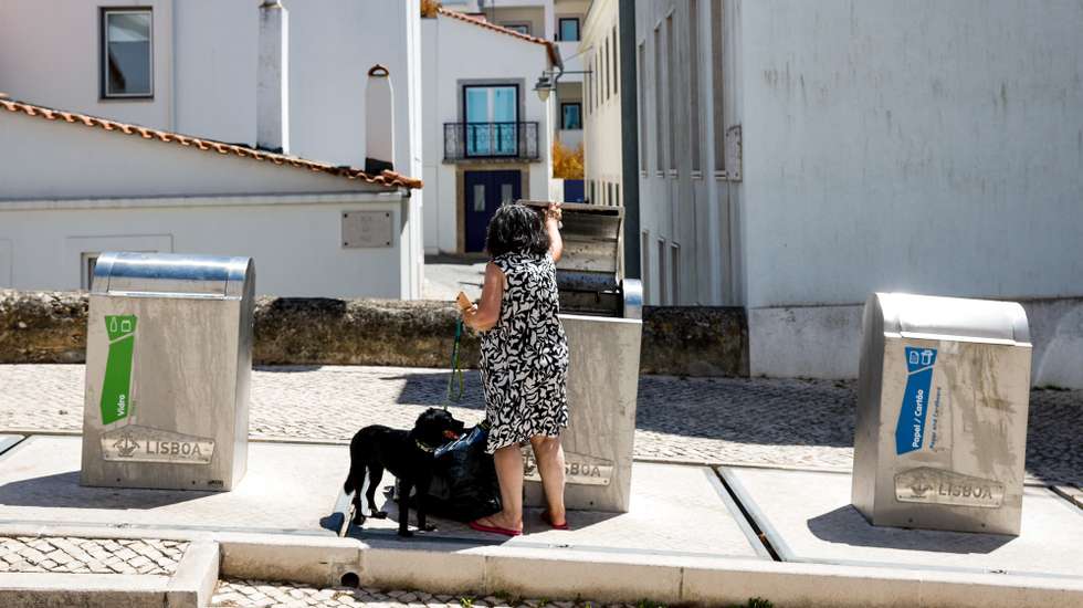 Uma mulher junto a um ecoponto no bairro da Ajuda, em Lisboa, 13 de agosto de 2024. Ecoponto. Lixo. Resíduos sólidos. Reciclagem. ANTÓNIO PEDRO SANTOS/LUSA