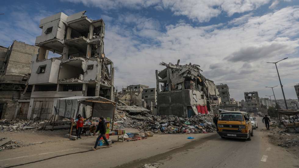 epa11882776 Palestinians walk past destroyed houses amid a ceasefire between Israel and Hamas, in Gaza City, 08 February 2025. Israel and Hamas implemented the first phase of a hostage release and ceasefire deal on 19 January 2025. More than 48,000 Palestinians have been killed in the Gaza Strip, according to the Palestinian Ministry of Health, since Israel launched a military campaign in the strip in response to a cross-border attack led by the Palestinian militant group Hamas on 07 October 2023, in which about 1,200 Israelis were killed and more than 250 taken hostage.  EPA/MOHAMMED SABER