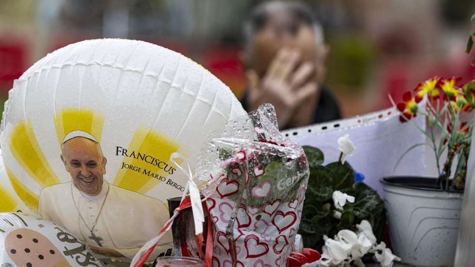 epaselect epa11923160 A man (back) prays outside the Agostino Gemelli hospital, where Pope Francis is currently hospitalized, in Rome, Italy, 25 February 2025. The pope was admitted to hospital on 14 February due to a respiratory tract infection.  EPA/MASSIMO PERCOSSI