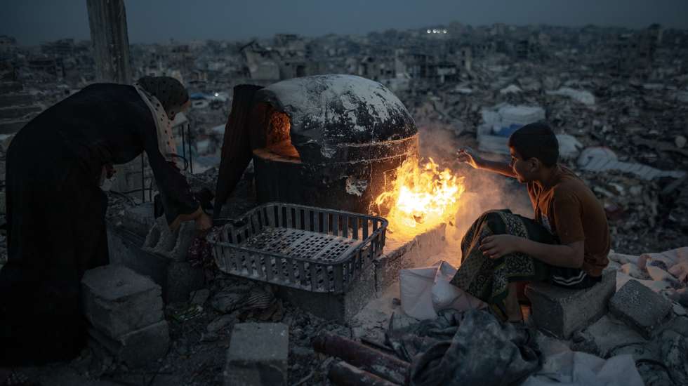 epa11970625 The Maarouf family prepares iftar over a fire in the rubble of their destroyed home during the holy month of Ramadan in Jabalia refugee camp, northern Gaza Strip, 17 March, 2025.  EPA/HAITHAM IMAD