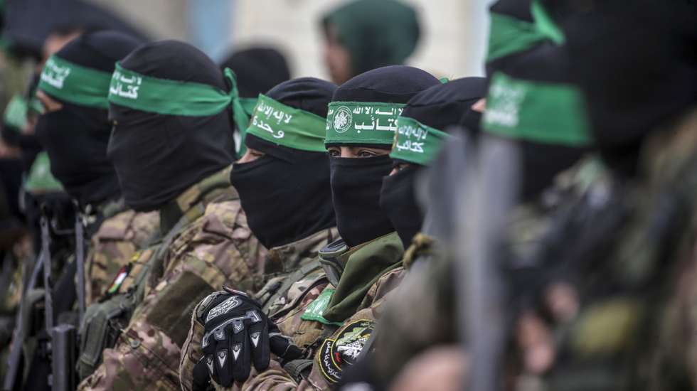 epa11915750 Armed fighters from Hamas' Izz ad-Din al-Qassam Brigades stand guard during the handover of three Israeli hostages to Red Cross representatives in Al Nuseirat refugee camp, central Gaza Strip, 22 February 2025. Six Israeli hostages were released on 22 February -- three in Nuseirat, two in Rafah and one in Gaza City -- after Hamas handed them over to the Red Cross in Gaza as part of the first phase of the Israel-Hamas ceasefire deal.  EPA/MOHAMMED SABER