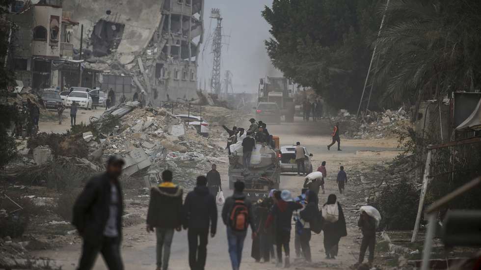 epa11845064 Internally displaced Palestinians walk among destroyed buildings amid a ceasefire between Israel and Hamas, in Rafah, southern Gaza Strip, 22 January 2025. Israel and Hamas implemented the first phase of a hostage release and ceasefire deal on 19 January 2025. More than 46,000 Palestinians have been killed in the Gaza Strip, according to the Palestinian Ministry of Health, since Israel launched a military campaign in the strip in response to a cross-border attack led by the Palestinian militant group Hamas on 07 October 2023, in which about 1,200 Israelis were killed and more than 250 taken hostage.  EPA/MOHAMMED SABER