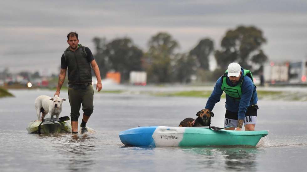 epa12111456 Two men transport dogs in kayaks across a flooded street, in Campana, Buenos Aires, Argentina, 17 May 2025. Some 2,800 people were evacuated this Saturday in the north and west of the province of Buenos Aires, amid the three-day rain storm that affected 30 Buenos Aires districts, according to official sources.  EPA/STR