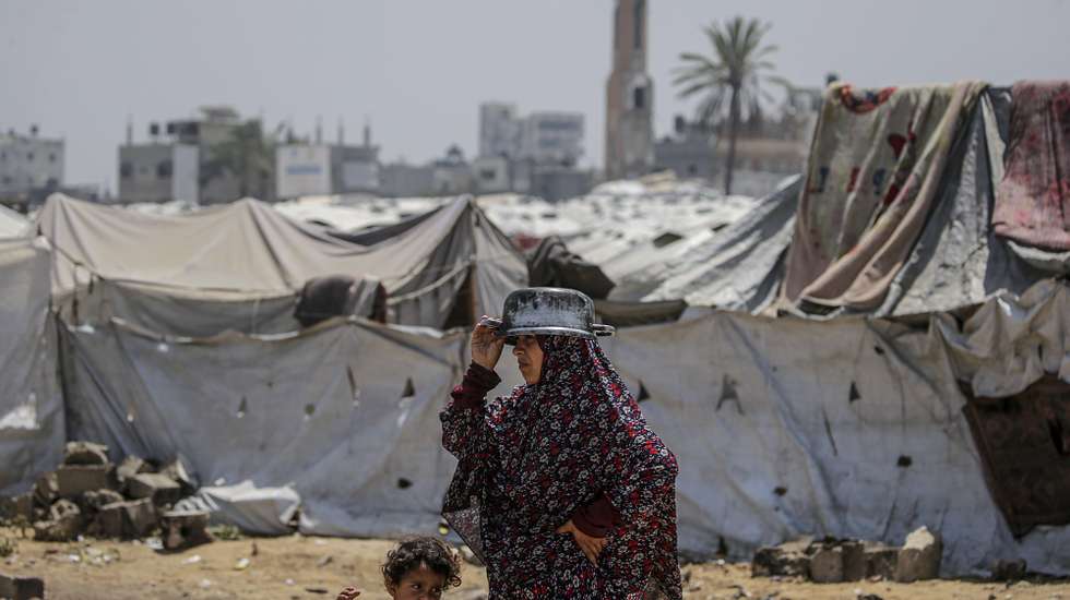 epa12086554 An internally displaced Palestinian woman waits to receive a portion of food from a charity kitchen, in Jabalia refugee camp, northern Gaza Strip, 09 May 2025. According to the UN Palestinian refugee agency UNRWA, over a million people across the Gaza Strip are experiencing 'high levels' of acute food insecurity, with acute malnutrition several times higher than before the war. The UN estimates at least 1.9 million people (nine in ten) are internally displaced.  EPA/MOHAMMED SABER