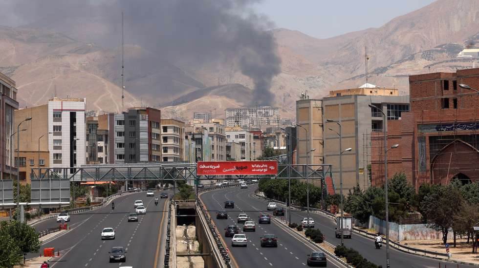 epa12178551 Cars drive along a motorway as smoke rises in the background from an oil refinery, northwest of Tehran, Iran, 16 June 2025. Israel and Iran have been exchanging fire since Israel launched strikes across Iran on 13 June 2025 as part of Operation 'Rising Lion.'  EPA/ABEDIN TAHERKENAREH